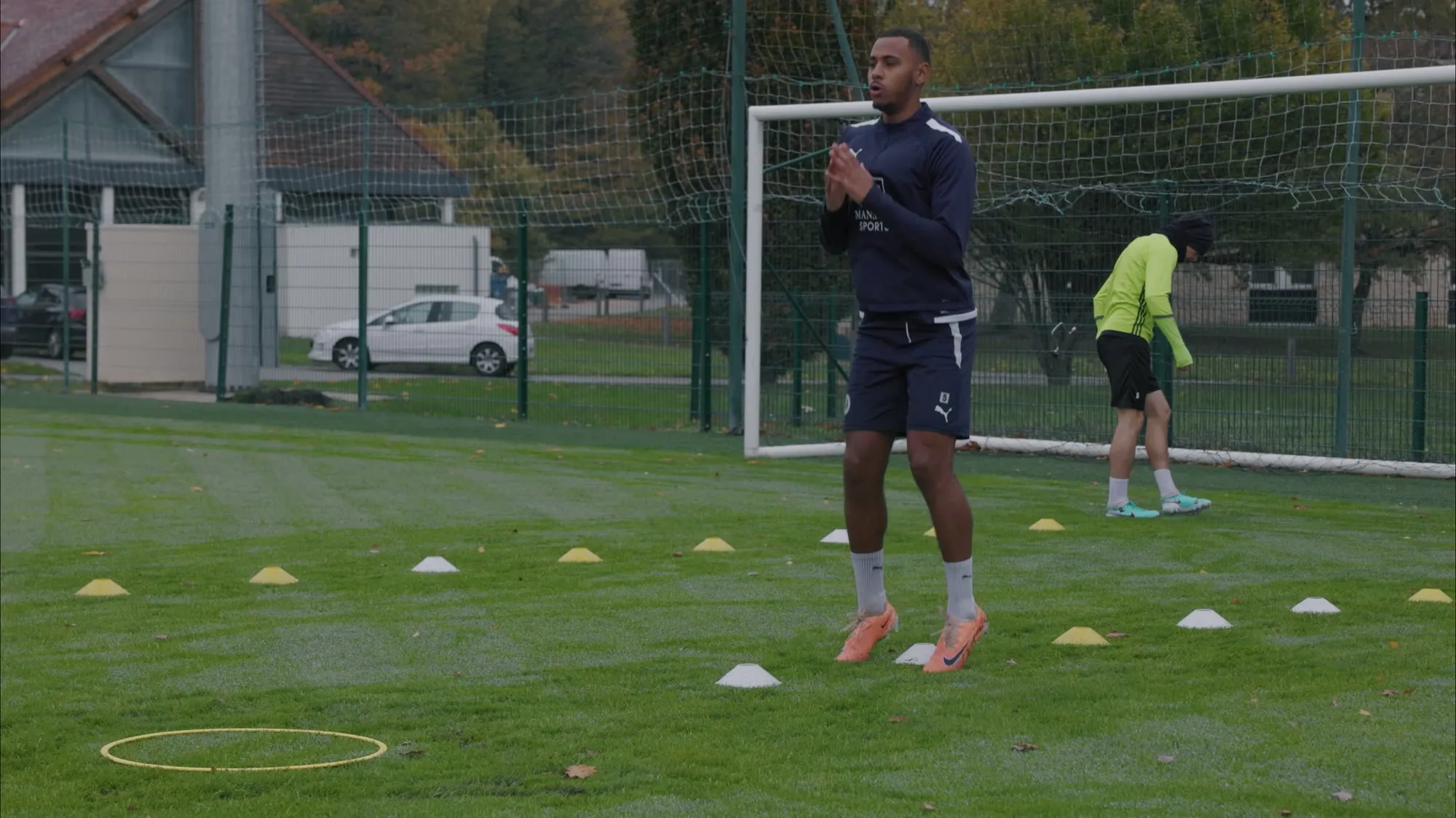Joueur à l’entraînement sur un terrain de football, plan d’un reportage